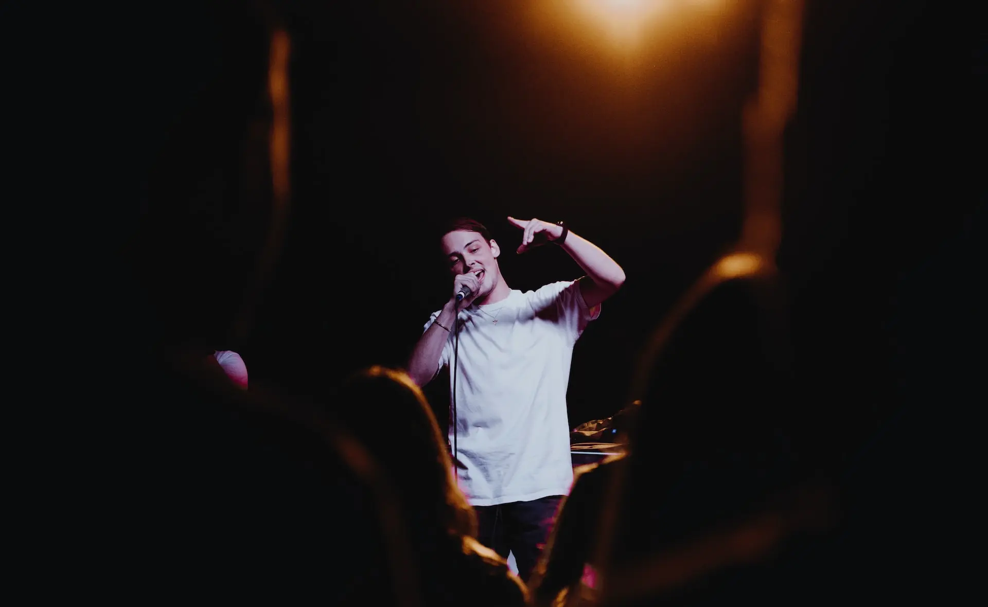 man raising his left hand while singing
